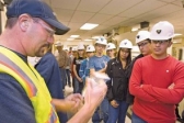 Scott Torrence, left, shows an ore sampling to Wells High School students. (Photo: Ross Andreson/Elko Daily Free Press)